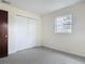 Bedroom with light walls, gray carpeting, closet, and natural light from a window at 202 Oakleigh Dr # 90, Deland, FL 32724