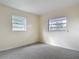 Bright bedroom featuring neutral walls and carpet, and two windows at 202 Oakleigh Dr # 90, Deland, FL 32724