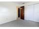 Bedroom featuring light walls, gray carpeting, and closet for ample storage space at 202 Oakleigh Dr # 90, Deland, FL 32724