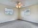 Bright bedroom featuring neutral carpet, a ceiling fan, and two windows at 202 Oakleigh Dr # 90, Deland, FL 32724