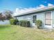 Lawn with green grass, exterior windows, and shrubs near the foundation of the home at 202 Oakleigh Dr # 90, Deland, FL 32724