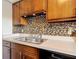 Traditional kitchen with wood cabinetry and a multi-colored tile backsplash at 202 Oakleigh Dr # 90, Deland, FL 32724