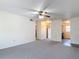 Spacious living room with neutral carpeting, bright lighting, and convenient kitchen access at 202 Oakleigh Dr # 90, Deland, FL 32724