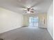 Open living area with comfortable carpeting, patio access, and a traditional ceiling fan at 202 Oakleigh Dr # 90, Deland, FL 32724