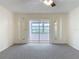 Bright living room boasts sliding glass doors, neutral carpet, and classic ceiling fan at 202 Oakleigh Dr # 90, Deland, FL 32724