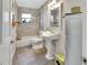 Bright bathroom featuring gray tile, a pedestal sink and combination tub and shower at 230 White Dove Ave, Orange City, FL 32763