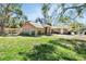 Well-maintained brick home with a spacious lawn and mature trees providing ample shade at 230 White Dove Ave, Orange City, FL 32763