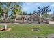 Charming brick home featuring a black metal fence with brick pillars and mature landscaping at 230 White Dove Ave, Orange City, FL 32763