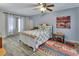Comfortable bedroom with wood floors, neutral walls, ceiling fan, and a large window for natural light at 230 White Dove Ave, Orange City, FL 32763
