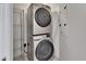 Convenient, stacked washer and dryer units with shelving at 231 Riverside Dr # 1801-1, Daytona Beach, FL 32117