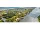 Scenic aerial view showcasing the riverfront home nestled among trees and houses, with the ocean visible in the background at 2852 John Anderson Dr, Ormond Beach, FL 32176