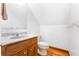 Small bathroom with a wood vanity, marble countertop, toilet, and angled ceiling at 2852 John Anderson Dr, Ormond Beach, FL 32176