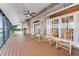 Covered brick porch with ceiling fans and rocking chairs overlooking a lake at 2852 John Anderson Dr, Ormond Beach, FL 32176