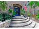 Charming front entrance with a blue door, decorative plants, and stone steps at 2852 John Anderson Dr, Ormond Beach, FL 32176