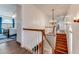 Hallway showcases a staircase with wooden railing, leading to an open area with views of a lake at 2852 John Anderson Dr, Ormond Beach, FL 32176