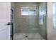 Modern shower featuring gray tile, pebble floor, and window for natural light at 2852 John Anderson Dr, Ormond Beach, FL 32176