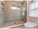 Shower area with a glass door and tiled walls, complemented by decorative pebble flooring at 2852 John Anderson Dr, Ormond Beach, FL 32176