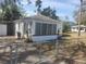Charming home featuring a white picket fence, mature landscaping, and a cozy sunroom at 333 8Th St, Daytona Beach, FL 32117