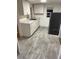Cozy kitchen with white cabinets, stainless steel sink, gray countertops, and laminate flooring at 333 8Th St, Daytona Beach, FL 32117