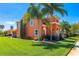 Charming two-story home featuring lush landscaping and a well-manicured lawn under a clear blue sky at 3346 Pegaso Ave, New Smyrna Beach, FL 32168