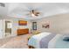 Spacious main bedroom with tray ceiling, ceiling fan, dresser and ensuite bathroom with tile flooring at 3346 Pegaso Ave, New Smyrna Beach, FL 32168