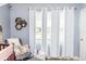 Bedroom with a grey accent wall, a plush chair, and neutral-toned curtains at 339 Spruce Pine Dr, Debary, FL 32713