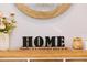 Charming 'Home' decor piece on a wooden shelf with flowers at 339 Spruce Pine Dr, Debary, FL 32713