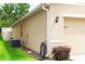 Side of house showing landscaping, garage door, and AC unit at 339 Spruce Pine Dr, Debary, FL 32713