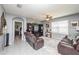 Comfortable living room with a leather reclining sofa, a ceiling fan, and a large window at 339 Spruce Pine Dr, Debary, FL 32713