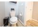 Toilet, metal trash can, and flower arrangement in half-bath room, next to the door at 339 Spruce Pine Dr, Debary, FL 32713