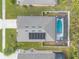 An aerial view of a home with solar panels and a screened in swimming pool, view is from the top down at 347 Admiralty Ct, Edgewater, FL 32141