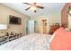 Comfortable bedroom featuring stylish decor, including a ceiling fan, mounted TV, and neutral color palette at 347 Admiralty Ct, Edgewater, FL 32141