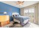 Bright bedroom with blue accent wall, ceiling fan, window, and stylish decor at 347 Admiralty Ct, Edgewater, FL 32141