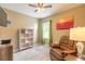 Cozy bedroom with a comfortable recliner, decorative bookshelf, and natural light from a window at 347 Admiralty Ct, Edgewater, FL 32141