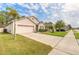 Inviting home exterior with a lush lawn, palm tree, two-car garage, and ample driveway space at 347 Admiralty Ct, Edgewater, FL 32141