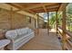 Cozy back porch with a wooden deck, comfortable wicker furniture, and a view of the lush backyard at 351 W Holly Dr, Orange City, FL 32763