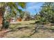 Spacious backyard with a mix of lush grass, trees, and partial fencing, ideal for outdoor activities at 351 W Holly Dr, Orange City, FL 32763