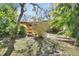 Well-maintained backyard with a brick home and a wooden deck framed by greenery and partial fencing at 351 W Holly Dr, Orange City, FL 32763