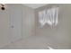 Bright bedroom featuring tile floors, a window with frilly white curtains, and a neutral color scheme at 351 W Holly Dr, Orange City, FL 32763