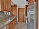 Well-lit kitchen features stainless steel appliances, wooden cabinetry, and tile flooring at 351 W Holly Dr, Orange City, FL 32763