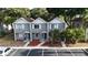 Two-story townhome with gray siding, white trim, a brown roof, well-manicured landscaping, and ample parking at 3960 Willow Trail Run # 45, Port Orange, FL 32127