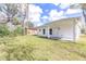 Spacious backyard with lush grass and a clean white exterior featuring a covered porch at 414 Ellsworth St, Daytona Beach, FL 32114