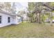 Spacious backyard with lush grass and a clean white exterior featuring a covered porch at 414 Ellsworth St, Daytona Beach, FL 32114