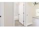 Modern bathroom featuring a white tub and door, complemented by stylish gray wood-look flooring at 414 Ellsworth St, Daytona Beach, FL 32114