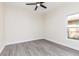 Bright bedroom with gray wood-look floors and a ceiling fan; ready to be personalized at 414 Ellsworth St, Daytona Beach, FL 32114