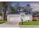 Charming home with a manicured lawn, two-car garage, and a vibrant turquoise front door, set against a colorful sky at 414 Ellsworth St, Daytona Beach, FL 32114