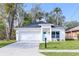 Charming single-story home with a white exterior, attached garage, and well-manicured front yard at 414 Ellsworth St, Daytona Beach, FL 32114