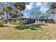 Spacious backyard featuring a well-maintained lawn, trees, and a patio area with seating at 4282 Alice St, Edgewater, FL 32141