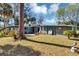 Spacious backyard featuring a well-maintained lawn, trees, and a patio area with seating at 4282 Alice St, Edgewater, FL 32141