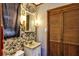 Quaint bathroom featuring floral wallpaper, wall-mounted sconces and a mirrored vanity at 4282 Alice St, Edgewater, FL 32141